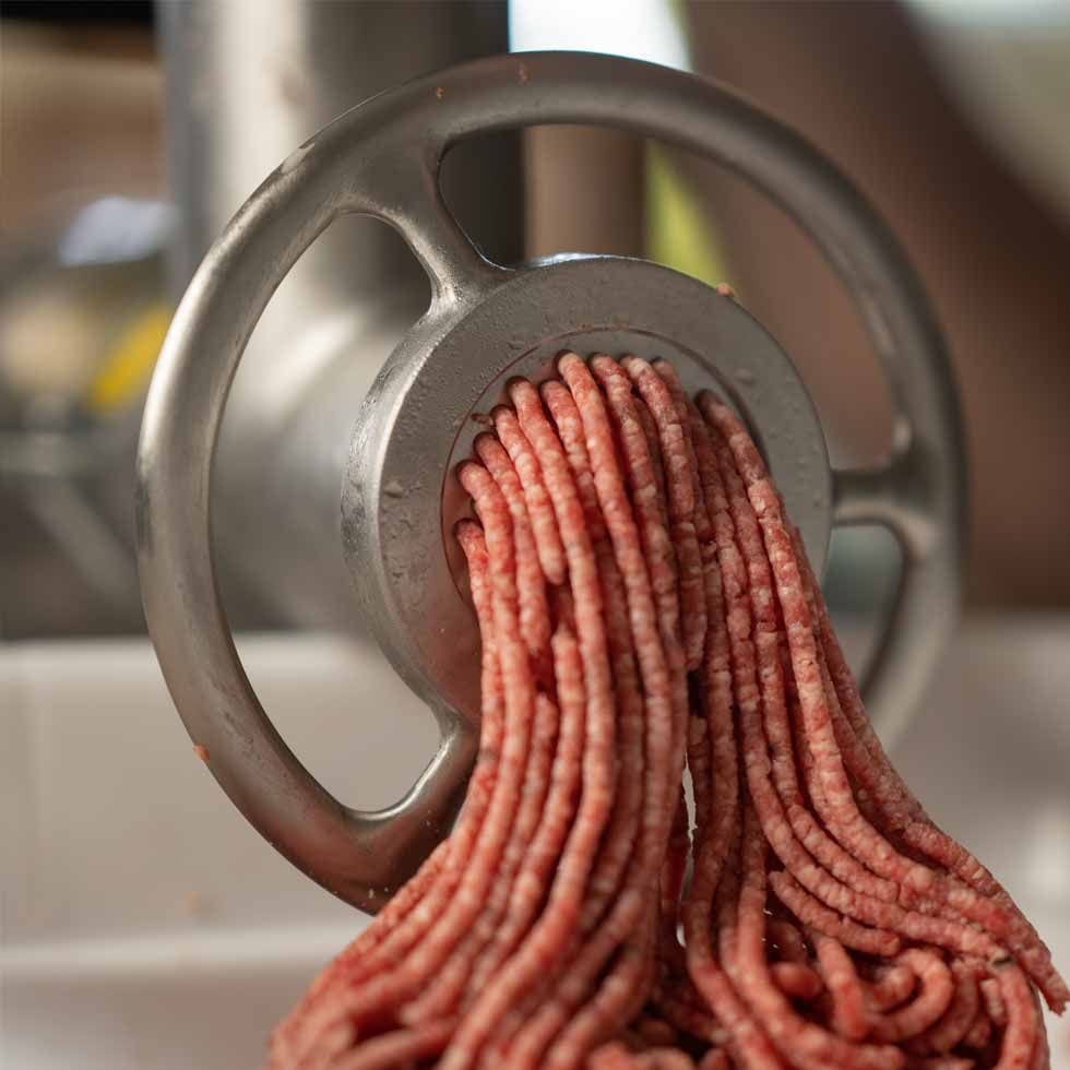 Ground meat coming out of a MEAT! Your Maker grinder plate