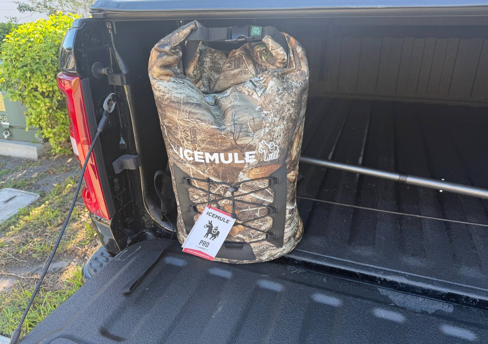 ICEMULE Pro 23L backpack cooler packed and clipped in a pickup truck bed