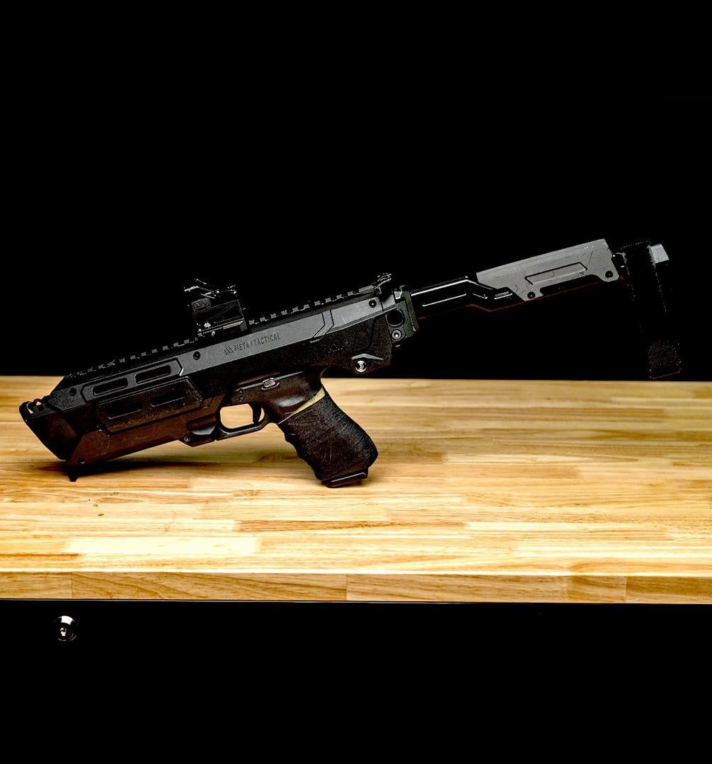Meta Tactical MX-1 with a Glock and red dot locked in, on a workbench